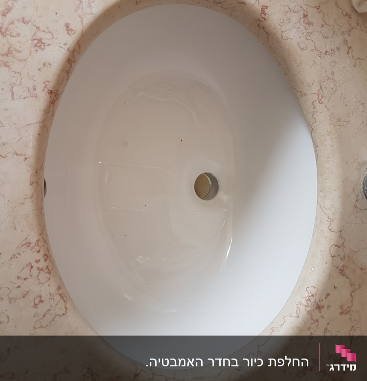כיור עגול על משטח שיש עם ורידים אדומים